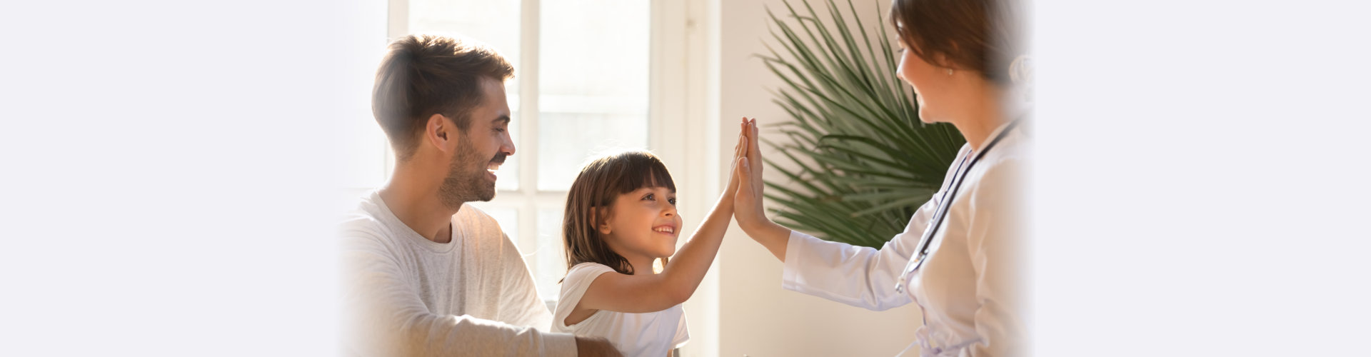 Healthy happy child girl giving high five to female caring doctor