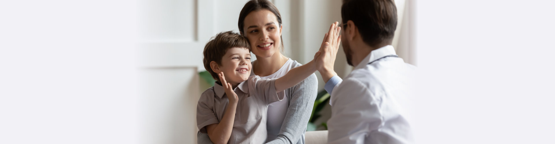 Overjoyed little boy patient have fun give high five to male doctor